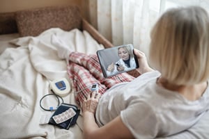 Women taking her blood oxygen level during virtual visit with nurse