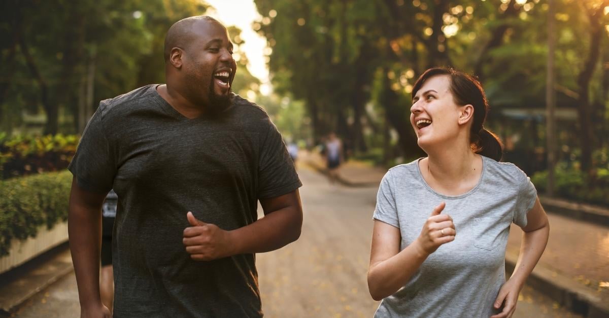 A man and a woman are running at a park