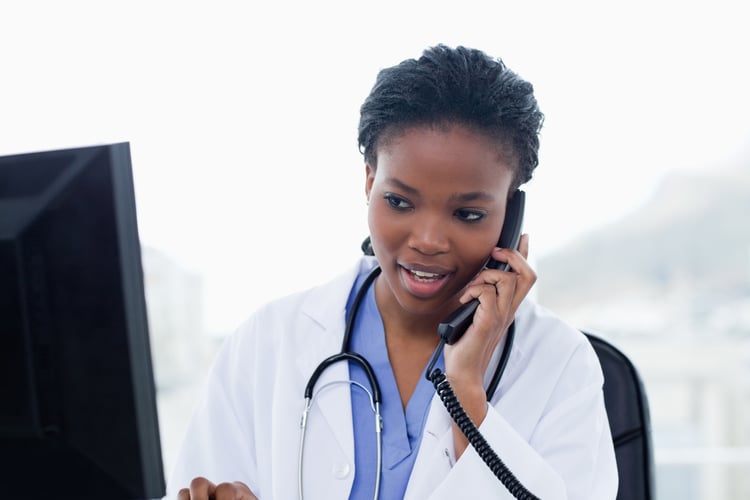 Female doctor on the phone while using a computer in her office