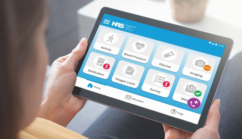 A patient on an RPM program powered by HRS uses a tablet to record vital signs, virtually communicate with their healthcare provider, and learn about their condition.