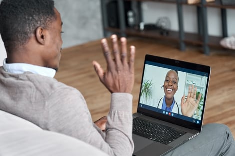 Doctor and patient waving during virtual visit