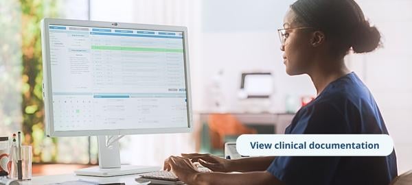 A clinician is reviewing an electronic health record for a patient on the computer. On screen text says 