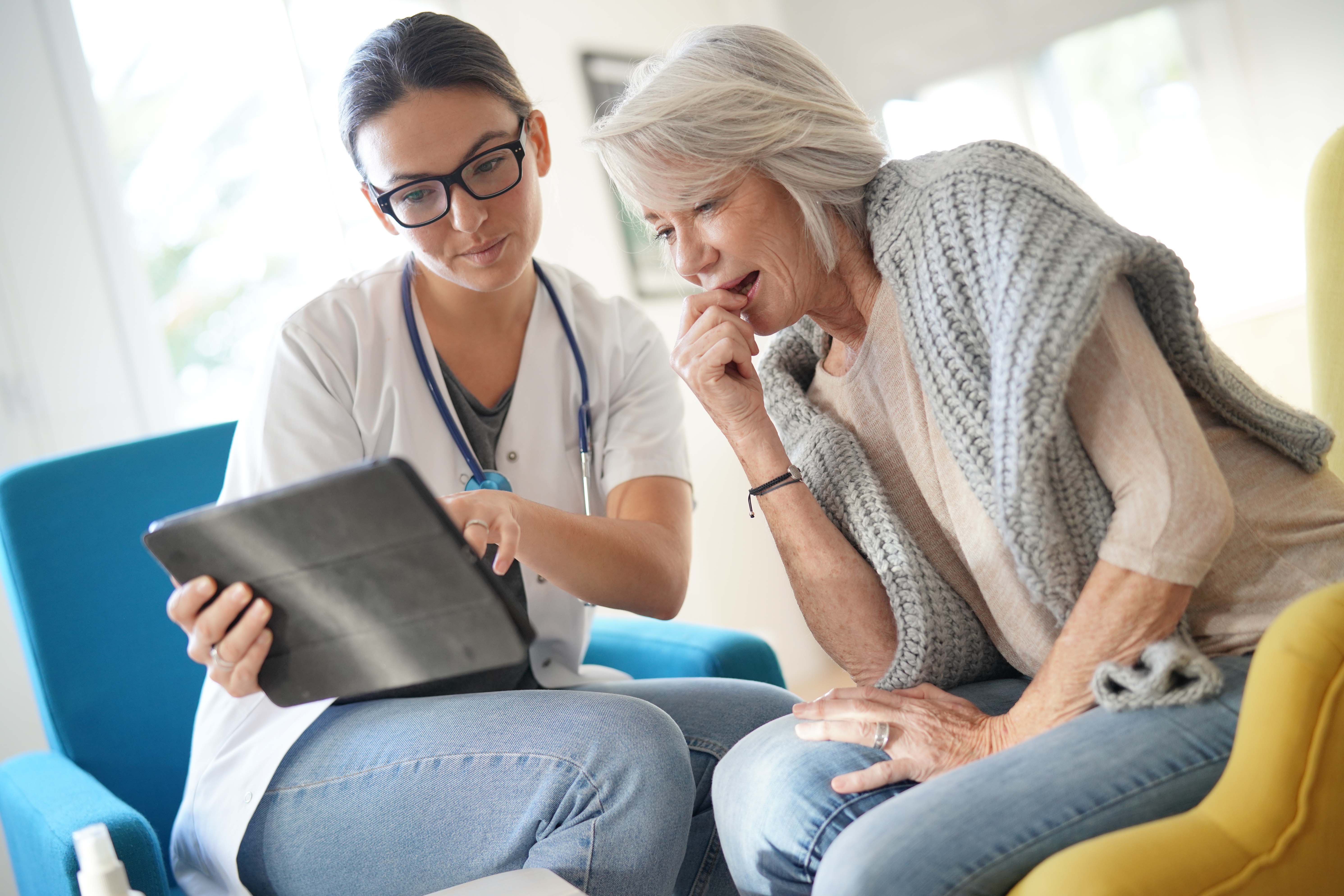 Physician demonstrating to patient how to operate telehealth tablet